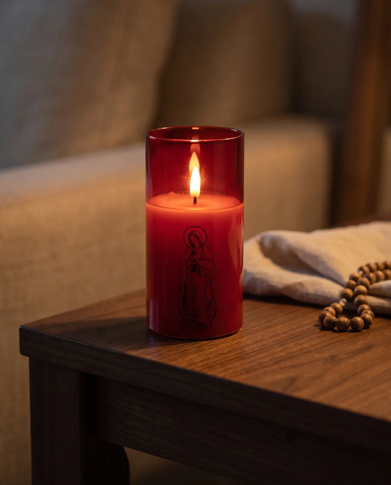 Red glass saint candle glowing on a side table in the evening